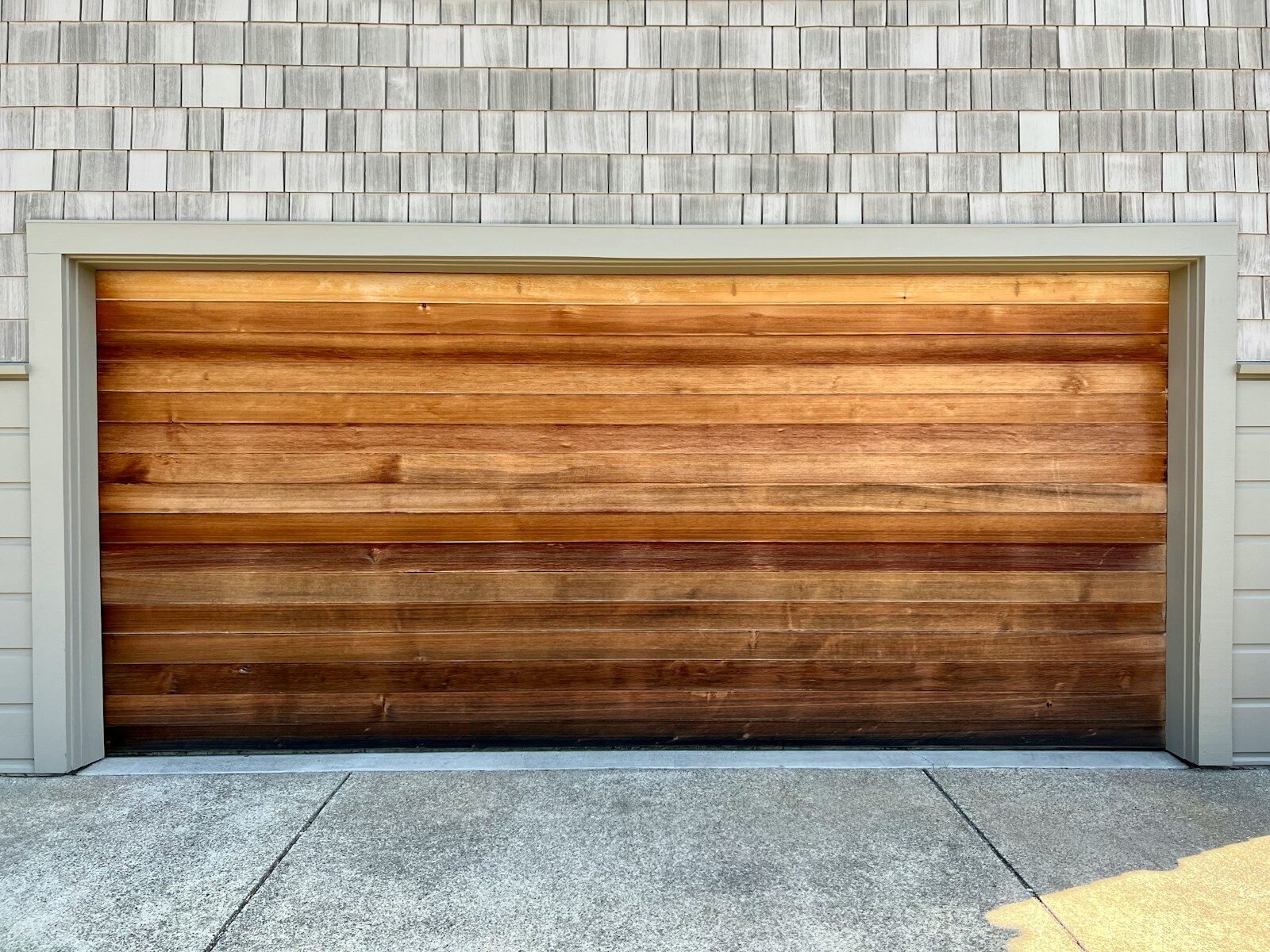 A wooden garage door on a brick building